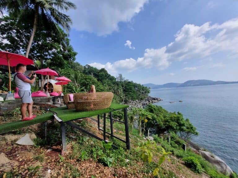 Tropical hillside with ocean view and pink umbrellas.