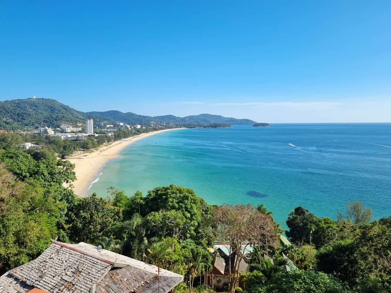 Scenic beach with turquoise waters and lush hills.