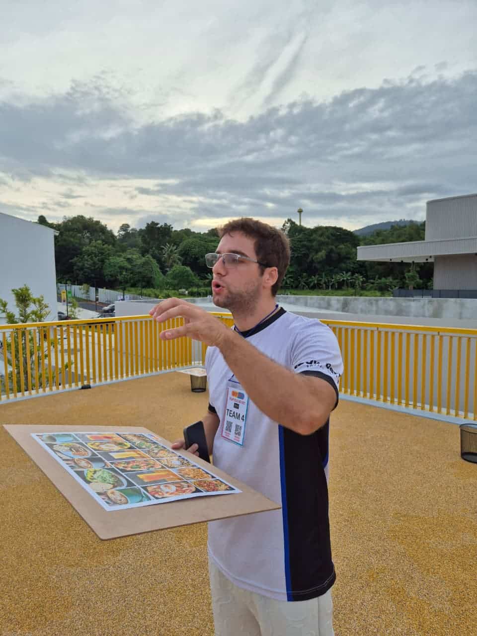Person holding menu board outdoors, trees in background.