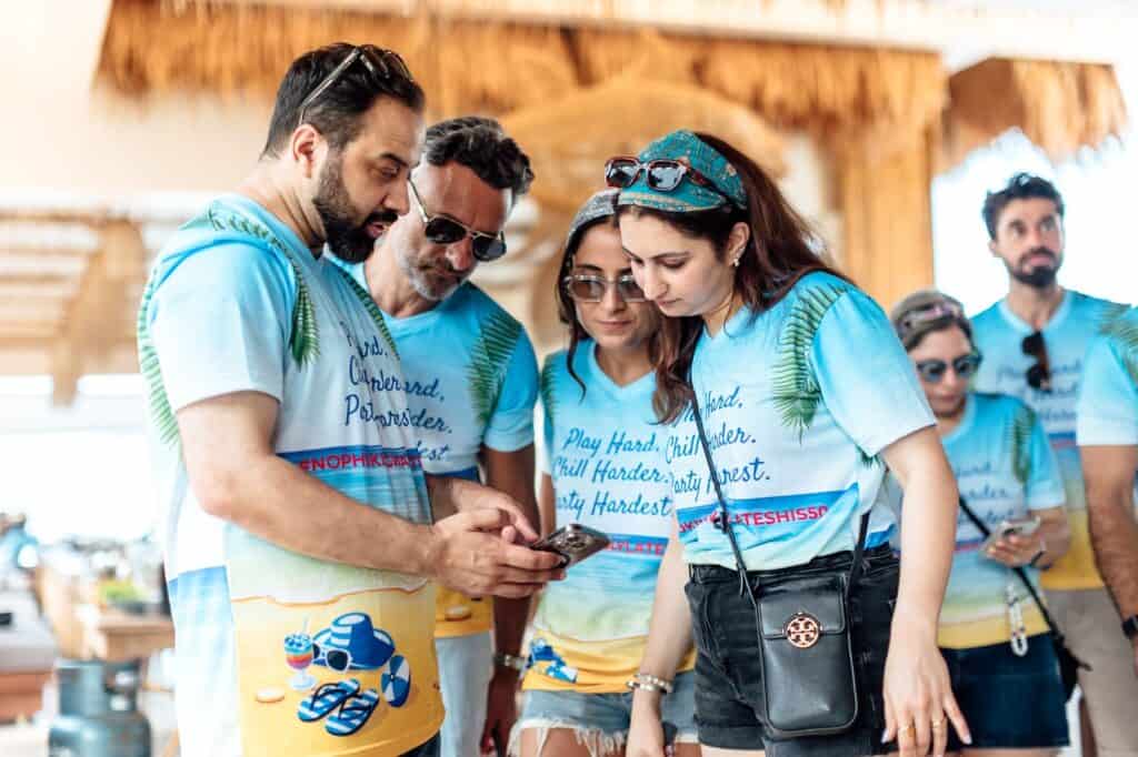 Group of people in matching beach-themed shirts.