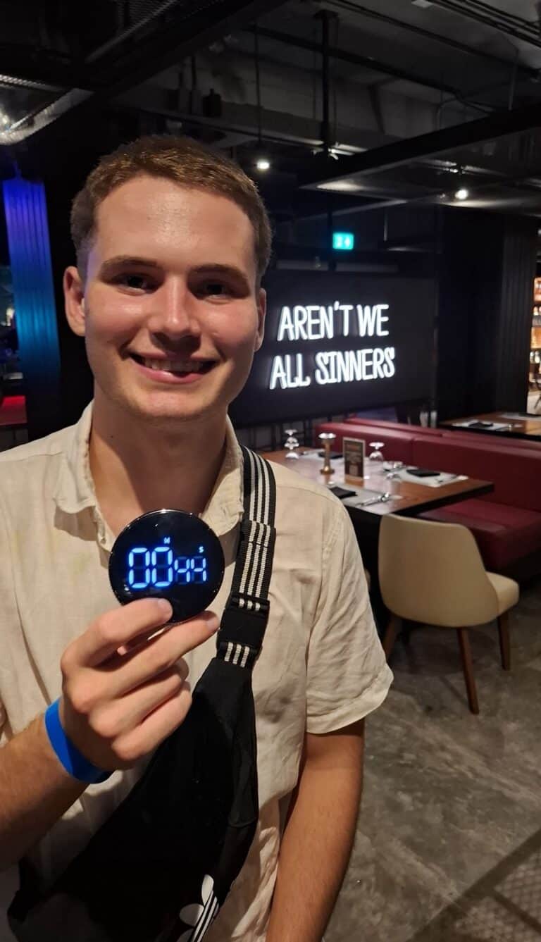 Person holding digital timer in restaurant.