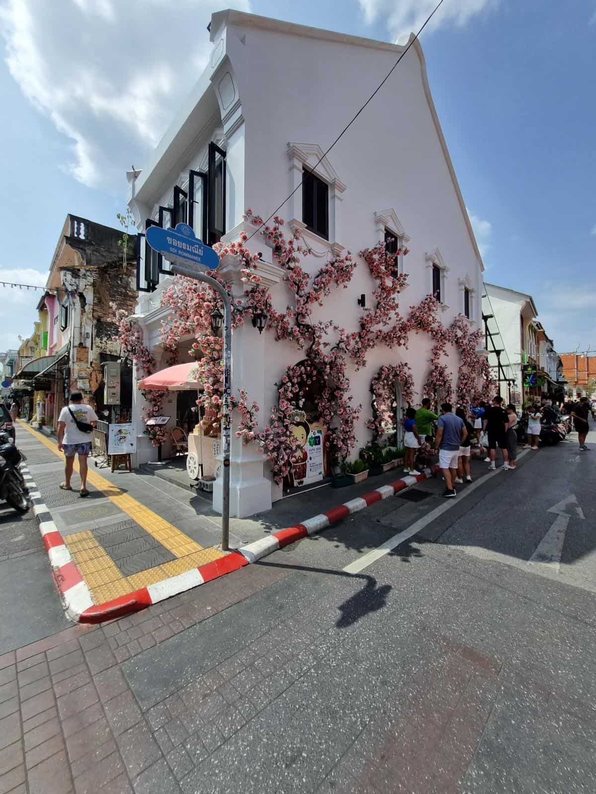 Charming street view with white building and flowers.