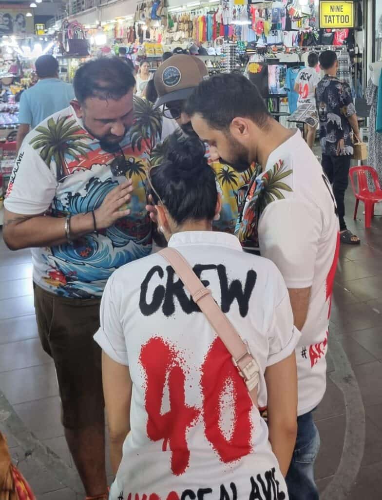 Group of people in printed shirts at market.