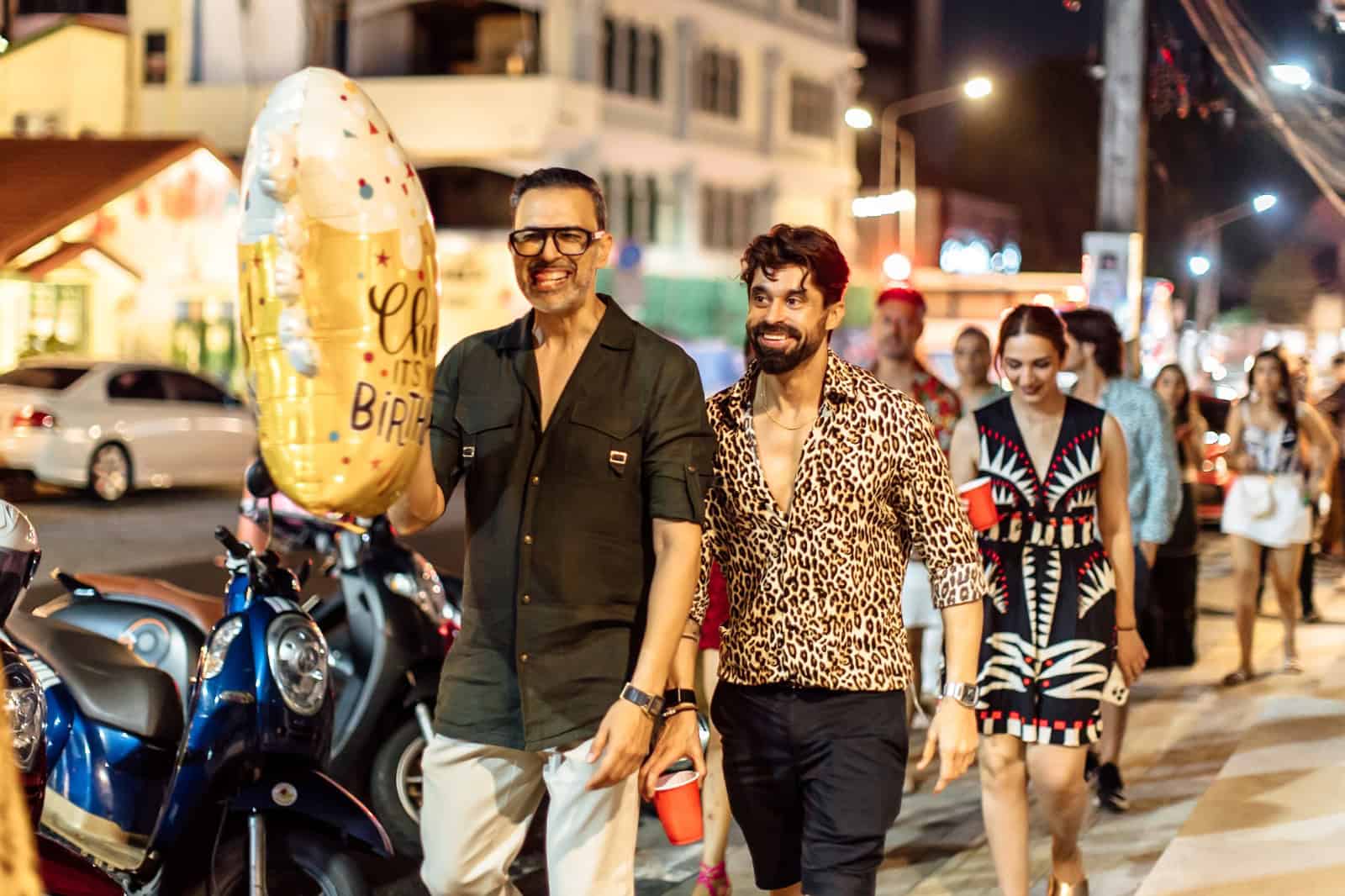 Group walking at night with birthday balloon.