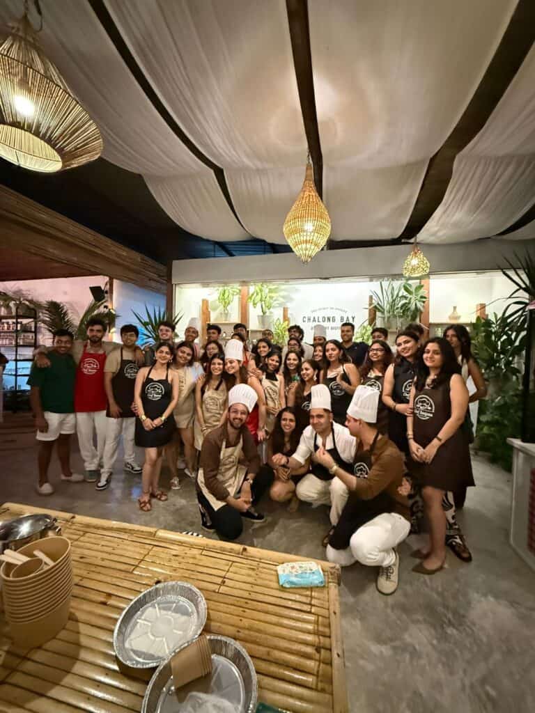 Group cooking class participants posing together indoors.