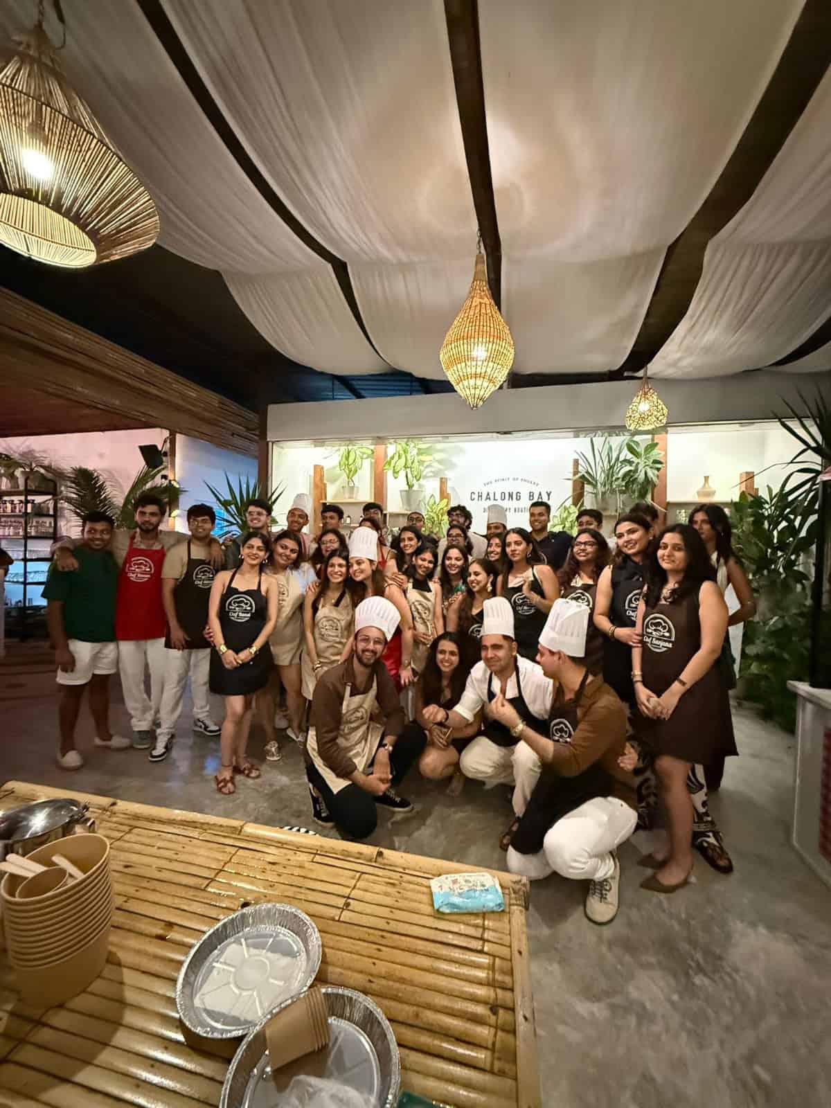 Group cooking class participants posing together indoors.