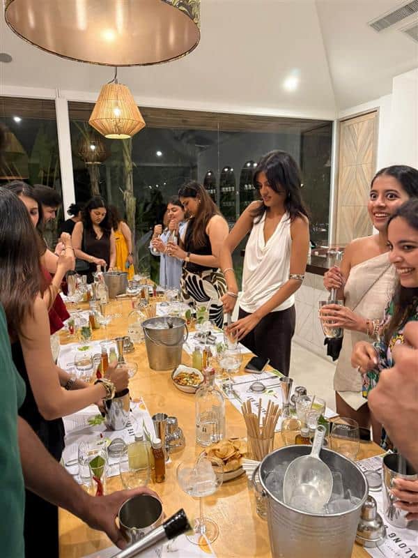 Group enjoying cocktail-making class at a gathering.