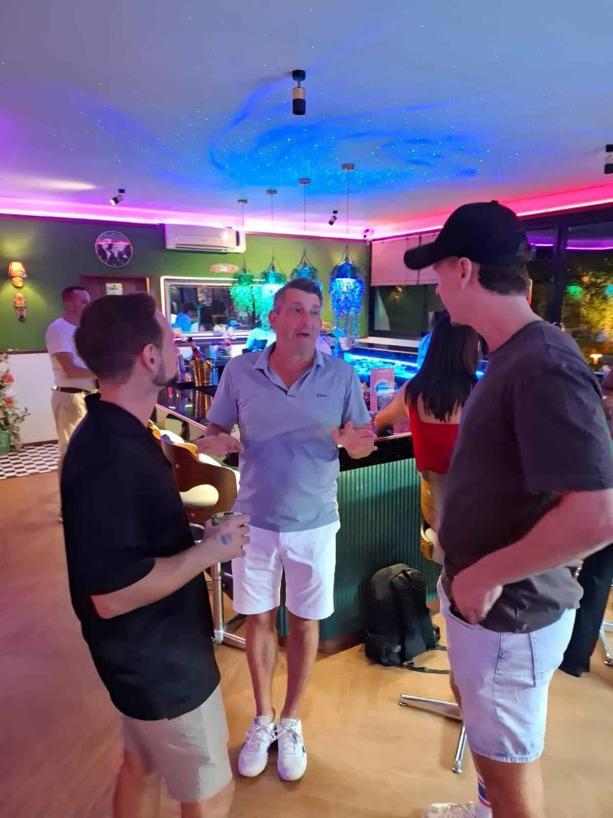People socializing in a colorful bar setting.